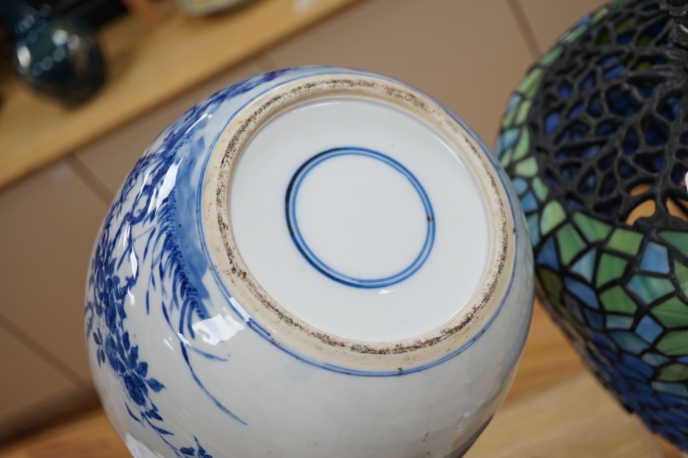 A large Chinese blue and white porcelain jar, 19th century decorated with scenes of birds amongst foliage with associated pierced hardwood cover and stand, 29cms high including stand and cover